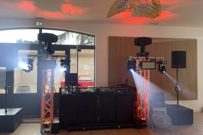 Installation de matériel de sonorisation et d'éclairage avec projecteurs et enceintes dans une salle de réception.