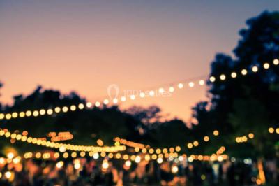 Ours en peluche avec un nœud rose devant un présentoir de cupcakes décorés dans un décor rose et lumineux.
