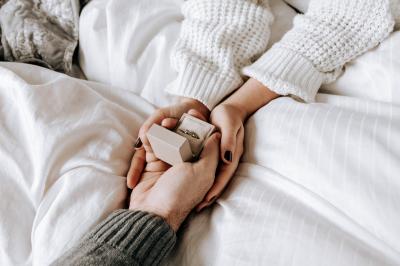 Ours en peluche avec un nœud rose devant un présentoir de cupcakes décorés dans un décor rose et lumineux.