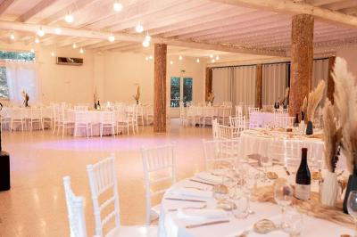 Portail en fer forgé noir et mur en pierre avec inscription ’Les Charbenes du Donelay, Domaine de réception’.