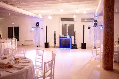 Portail en fer forgé noir et mur en pierre avec inscription ’Les Charbenes du Donelay, Domaine de réception’.