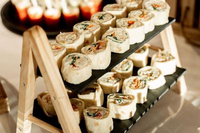 Portail en fer forgé noir et mur en pierre avec inscription ’Les Charbenes du Donelay, Domaine de réception’.