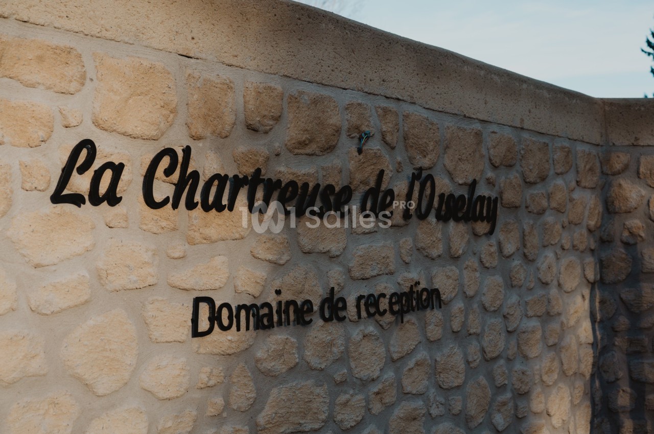 Mur en pierre avec l'inscription ’La Chartreuse de l'Oréalay, Domaine de réception’.