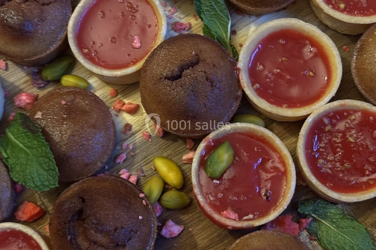Assortiment de tartelettes au chocolat et à la framboise, décorées de pistaches, menthe et éclats de fruits.