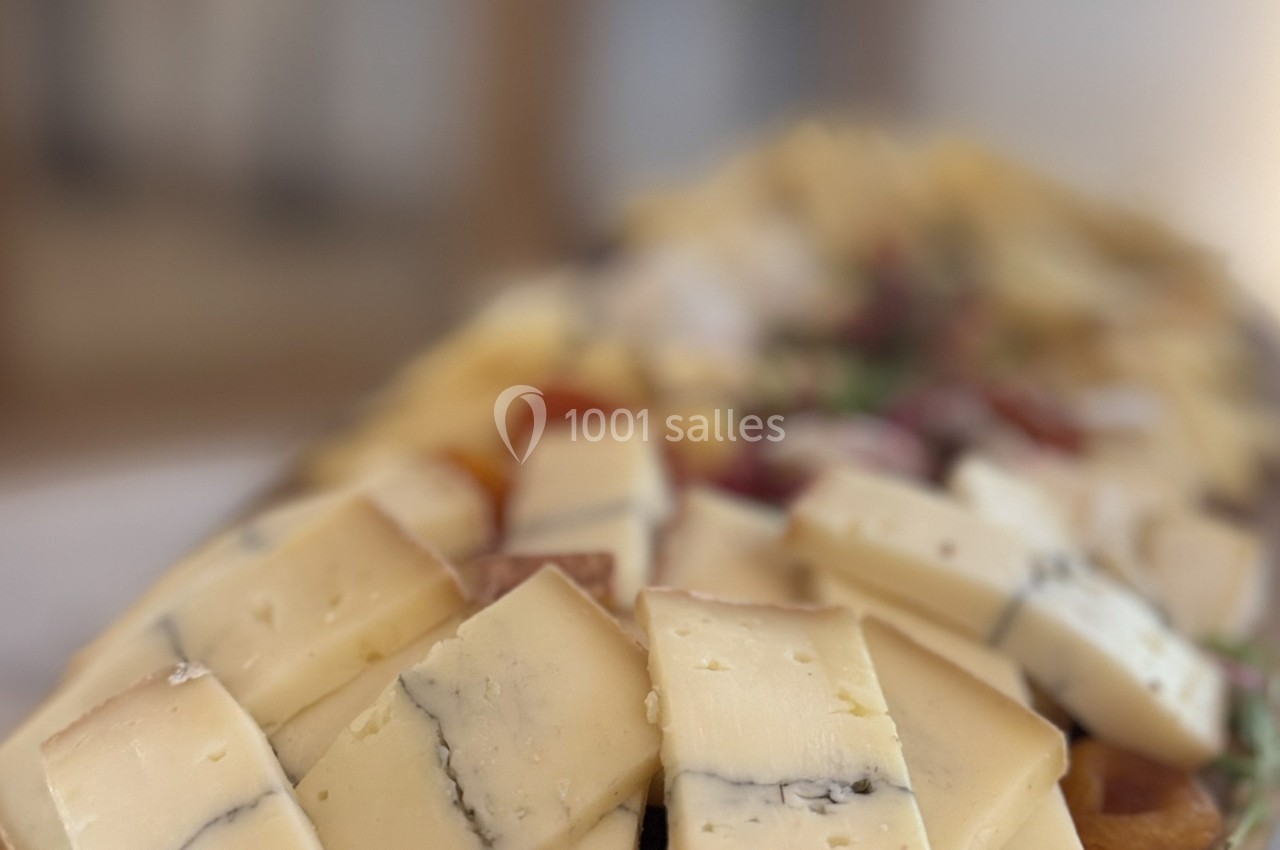 Plateau de fromages variés avec des morceaux de fromage à pâte dure et persillée, disposés sur une planche en bois.