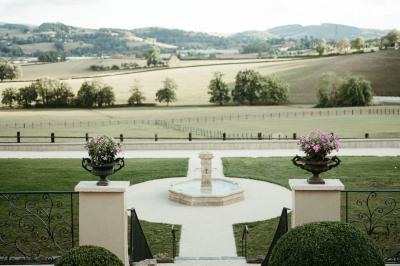Miniature Location salle Thizy (Rhône) - Château de Laforest #8 Paysage rural avec une clôture en bois, des champs verdoyants, des arbres et un bâtiment en pierre sous un ciel…