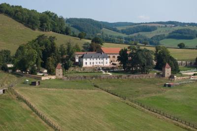 Miniature Location salle Thizy (Rhône) - Château de Laforest #7 Paysage rural avec une clôture en bois, des champs verdoyants, des arbres et un bâtiment en pierre sous un ciel…