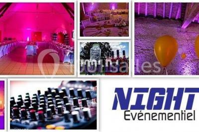 Structure en bois d'une halle éclairée par des lumières violettes, avec un toit en tuiles et des piliers en pierre.