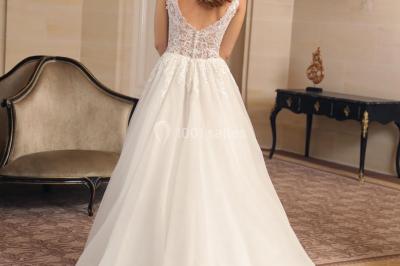 Miniature Ana Wedding Event #4 Femme portant une robe de mariée blanche avec détails en dentelle, debout sur des marches devant un bâtiment élégant.