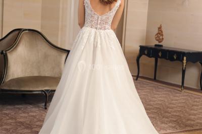 Miniature Ana Wedding Event #5 Femme portant une robe de mariée blanche avec détails en dentelle, debout sur des marches devant un bâtiment élégant.