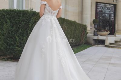 Miniature Ana Wedding Event #6 Femme portant une robe de mariée blanche avec détails en dentelle, debout sur des marches devant un bâtiment élégant.