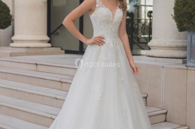 Miniature Ana Wedding Event #7 Femme portant une robe de mariée blanche avec détails en dentelle, debout sur des marches devant un bâtiment élégant.