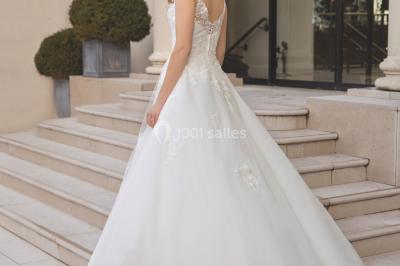 Miniature Ana Wedding Event #8 Femme portant une robe de mariée blanche avec détails en dentelle, debout sur des marches devant un bâtiment élégant.