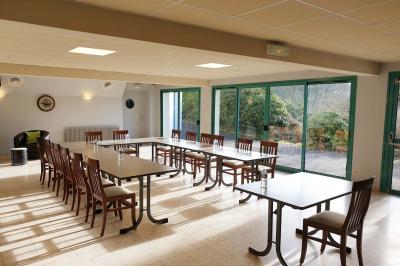 Miniature Location salle Ergué-Gabéric (Finistère) - L’Orée du Bois #7 Vue sur un jardin avec des arbres, une maison blanche et un paysage de campagne sous un ciel nuageux.