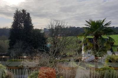 Miniature Location salle Ergué-Gabéric (Finistère) - L’Orée du Bois #14 Vue sur un jardin avec des arbres, une maison blanche et un paysage de campagne sous un ciel nuageux.