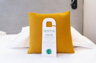 Miniature Location salle Lille (Nord) - Les Salons de l'Urban #39 Un coussin jaune sur un lit blanc avec une pancarte suspendue indiquant un message écologique.