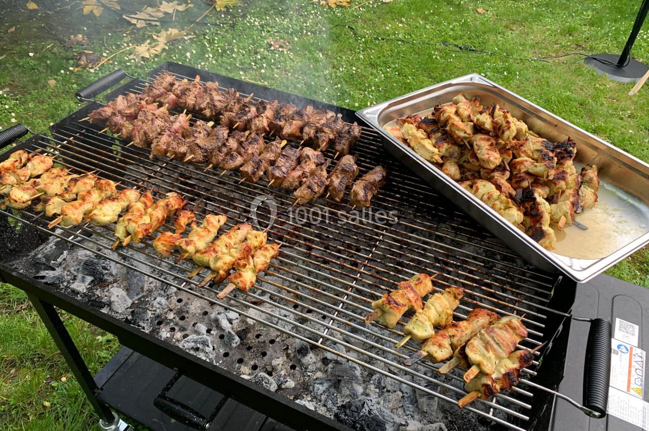Location salle Lille (Nord) - Les Salons de l'Urban #16 Brochettes de viande et de poulet grillées sur un barbecue, avec un plateau contenant des brochettes cuites à côté.
