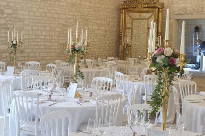 Image d'un château avec guirlandes lumineuses, un couple de mariés dans la cour et une salle de réception décorée.