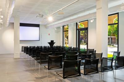 Vue nocturne d'un événement en plein air avec des stands sous une tente éclairée et des participants rassemblés.