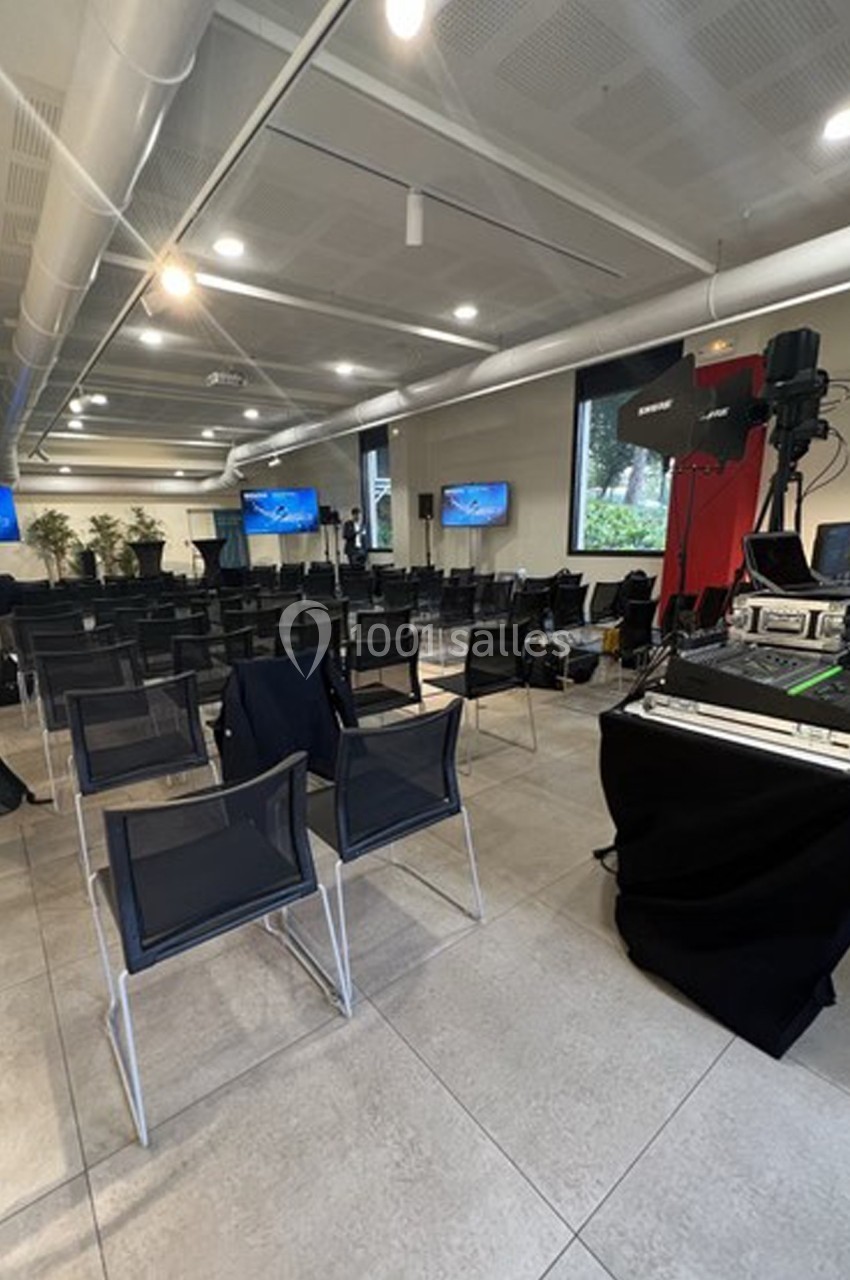 Location salle Lyon 9 (Rhône) - Le Fort de Vaise #32 Salle de conférence vide avec des chaises alignées, des écrans allumés et du matériel audiovisuel installé.