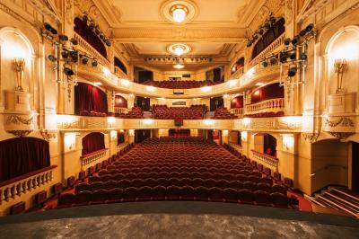 Escalier et couloir décoré de rouge avec fresque murale sculptée, éclairage chaleureux et moquette au sol.