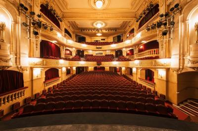 Escalier et couloir décoré de rouge avec fresque murale sculptée, éclairage chaleureux et moquette au sol.
