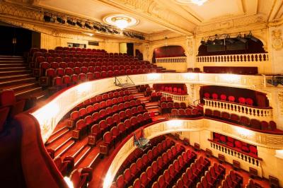 Escalier et couloir décoré de rouge avec fresque murale sculptée, éclairage chaleureux et moquette au sol.