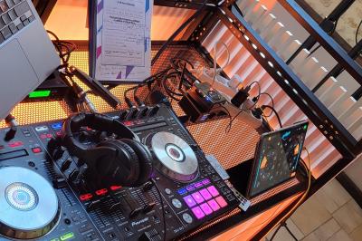 Miniature DJ Champigny-sur-Marne (Val-de-Marne) - Forever Event - DJ Garwell #13 Homme souriant portant un casque audio et un costume sombre, éclairé par une lumière douce sur fond noir.