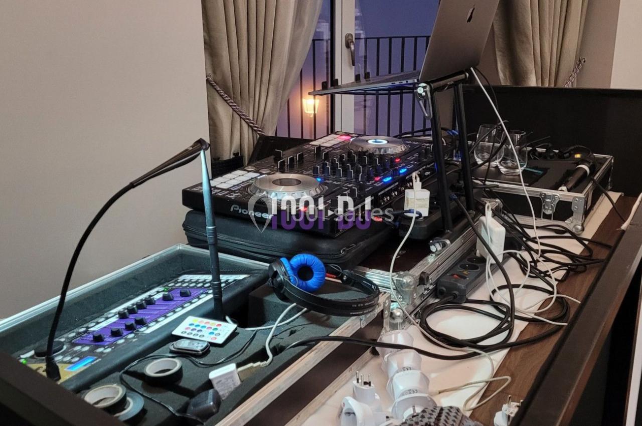 Équipement de DJ installé sur une table, comprenant une console, des câbles, un ordinateur portable et des casques audio.