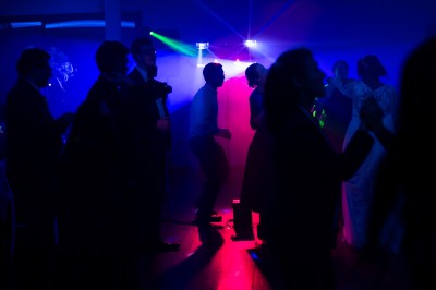 Installation de matériel audiovisuel avec éclairage violet, devant un mur décoré de fleurs blanches.