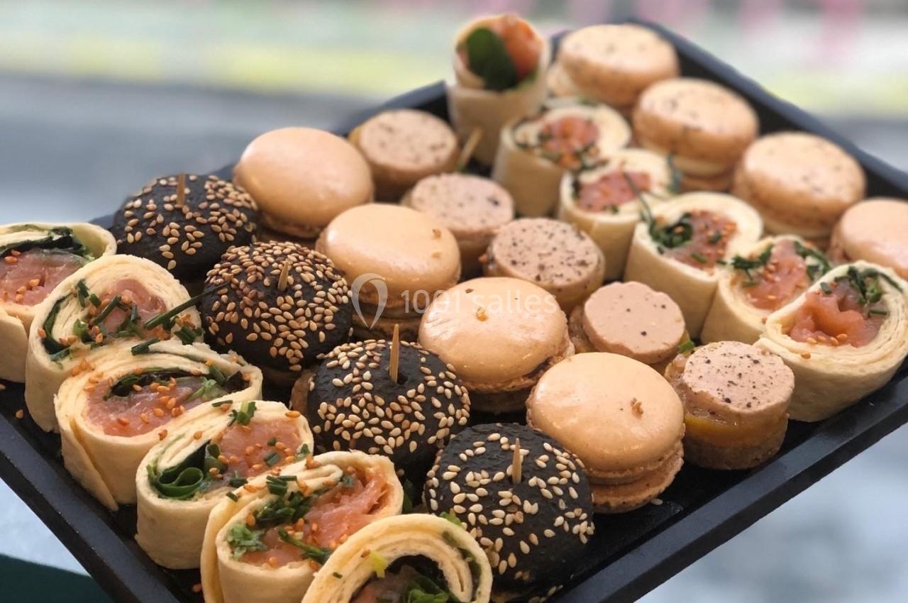 Plateau de bouchées apéritives comprenant wraps au saumon, macarons salés et mini-pains garnis.