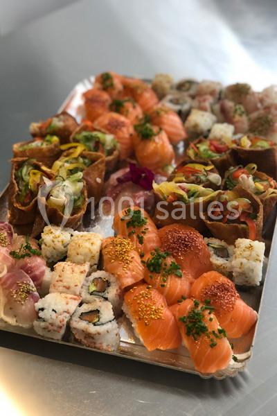 Plateau de sushis variés comprenant makis, nigiris au saumon et bouchées garnies de légumes colorés.