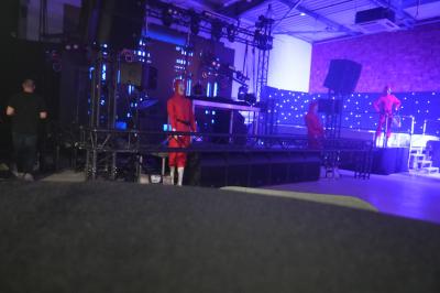 Un DJ mixe sur scène dans une ambiance sombre et lumineuse, décorée avec des éléments d'Halloween.