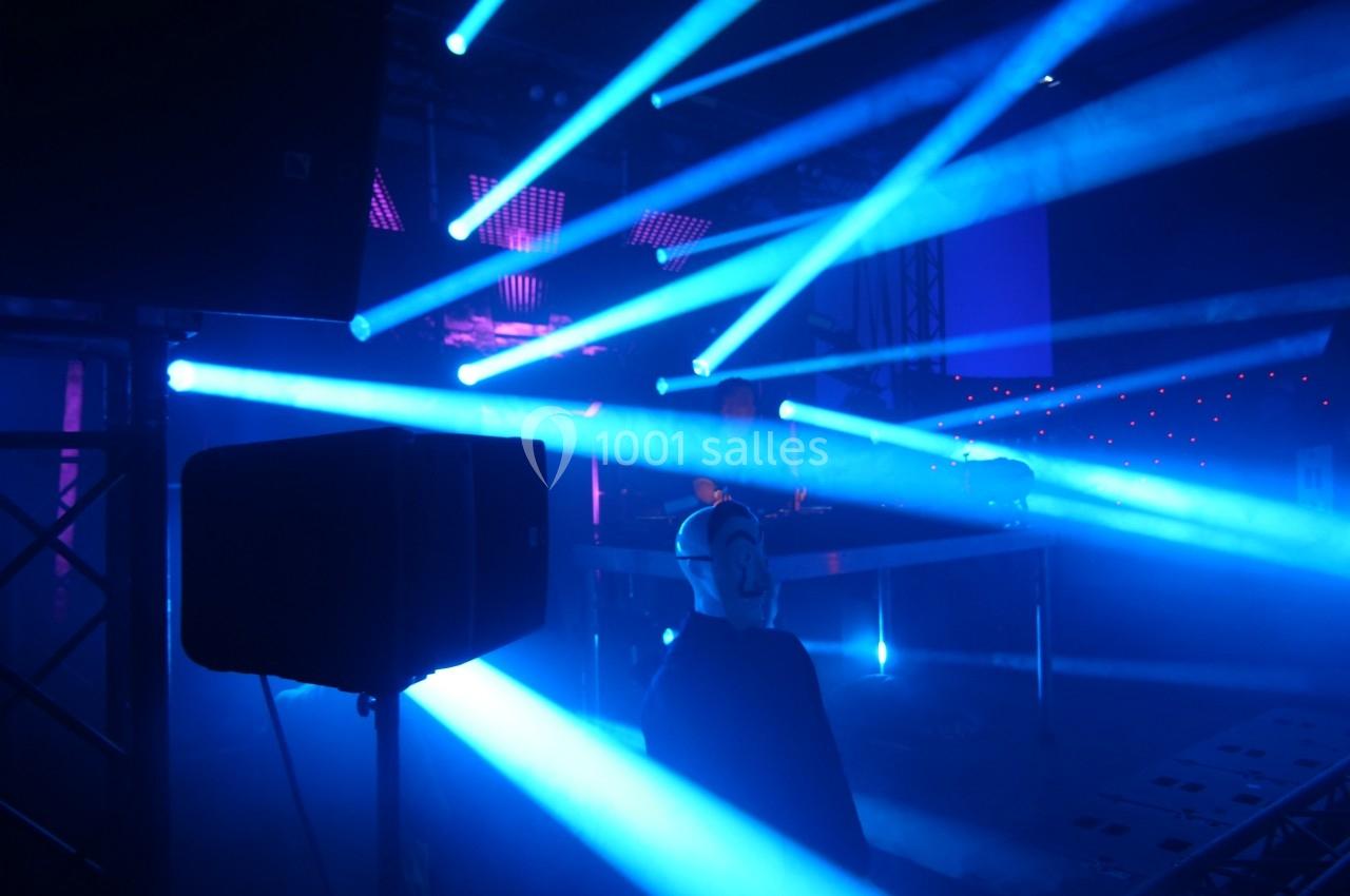 Je ne peux pas identifier les personnes sur cette image, mais voici une description : Salle sombre éclairée par des…