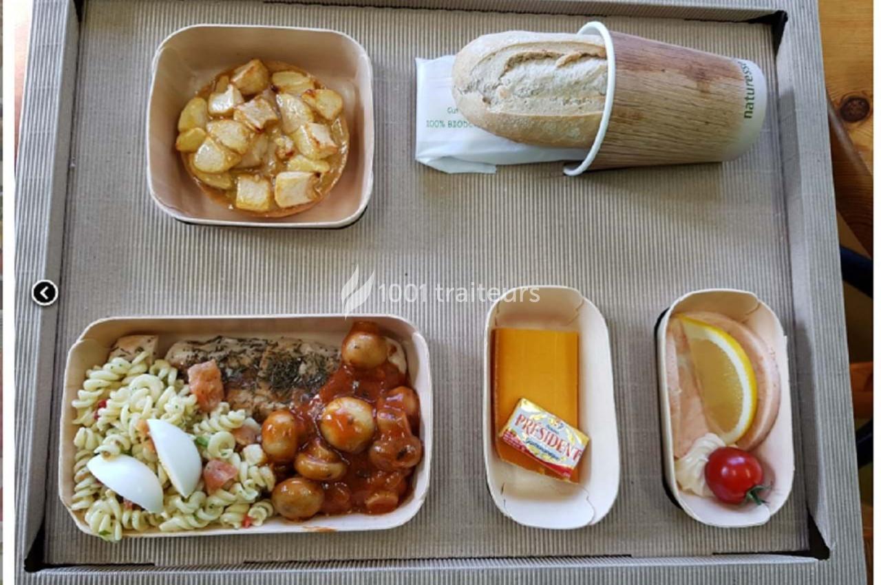 Plateau-repas avec pâtes, viande en sauce, pommes de terre, fromage, dessert, pain et beurre.