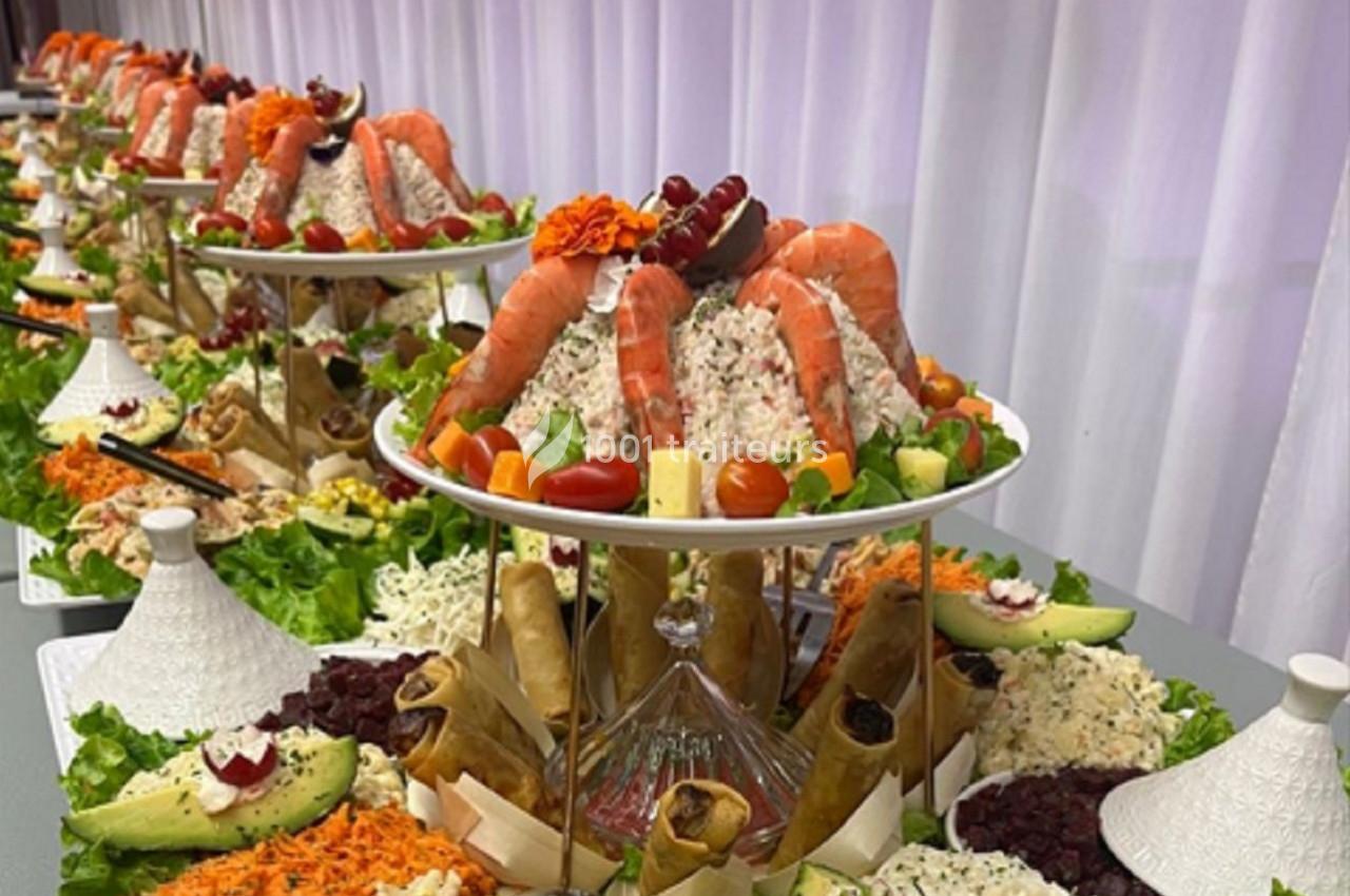 Plateau de buffet avec fruits de mer, légumes frais, rouleaux croustillants et garnitures variées sur plusieurs étages.