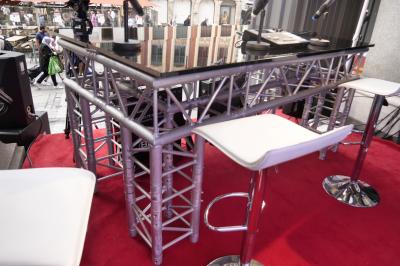 Un bus stationné de nuit devant un bâtiment illuminé, avec des passants en arrière-plan.