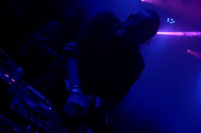 Un bus stationné de nuit devant un bâtiment illuminé, avec des passants en arrière-plan.