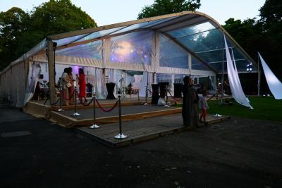 Un bus stationné de nuit devant un bâtiment illuminé, avec des passants en arrière-plan.