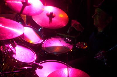 Un bus stationné de nuit devant un bâtiment illuminé, avec des passants en arrière-plan.