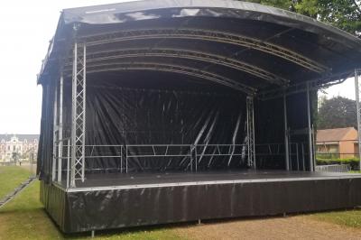 Un bus stationné de nuit devant un bâtiment illuminé, avec des passants en arrière-plan.