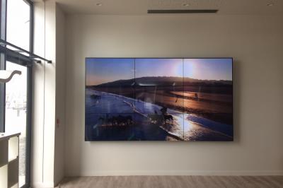 Un bus stationné de nuit devant un bâtiment illuminé, avec des passants en arrière-plan.