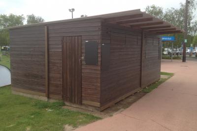 Un bus stationné de nuit devant un bâtiment illuminé, avec des passants en arrière-plan.