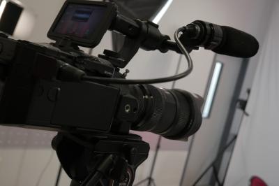 Un bus stationné de nuit devant un bâtiment illuminé, avec des passants en arrière-plan.