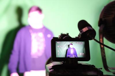 Un bus stationné de nuit devant un bâtiment illuminé, avec des passants en arrière-plan.