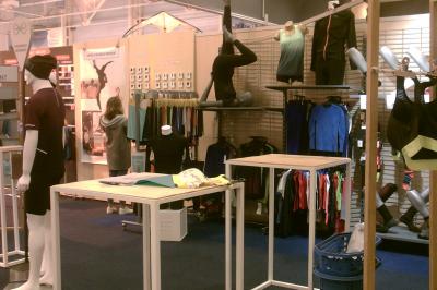 Un bus stationné de nuit devant un bâtiment illuminé, avec des passants en arrière-plan.