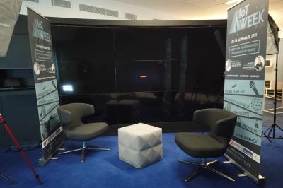 Un bus stationné de nuit devant un bâtiment illuminé, avec des passants en arrière-plan.