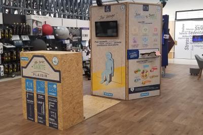 Un bus stationné de nuit devant un bâtiment illuminé, avec des passants en arrière-plan.