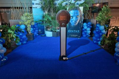 Un bus stationné de nuit devant un bâtiment illuminé, avec des passants en arrière-plan.