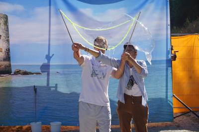 Un bus stationné de nuit devant un bâtiment illuminé, avec des passants en arrière-plan.